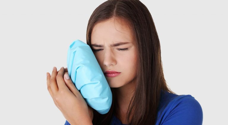 девушка приложила лед к щеке